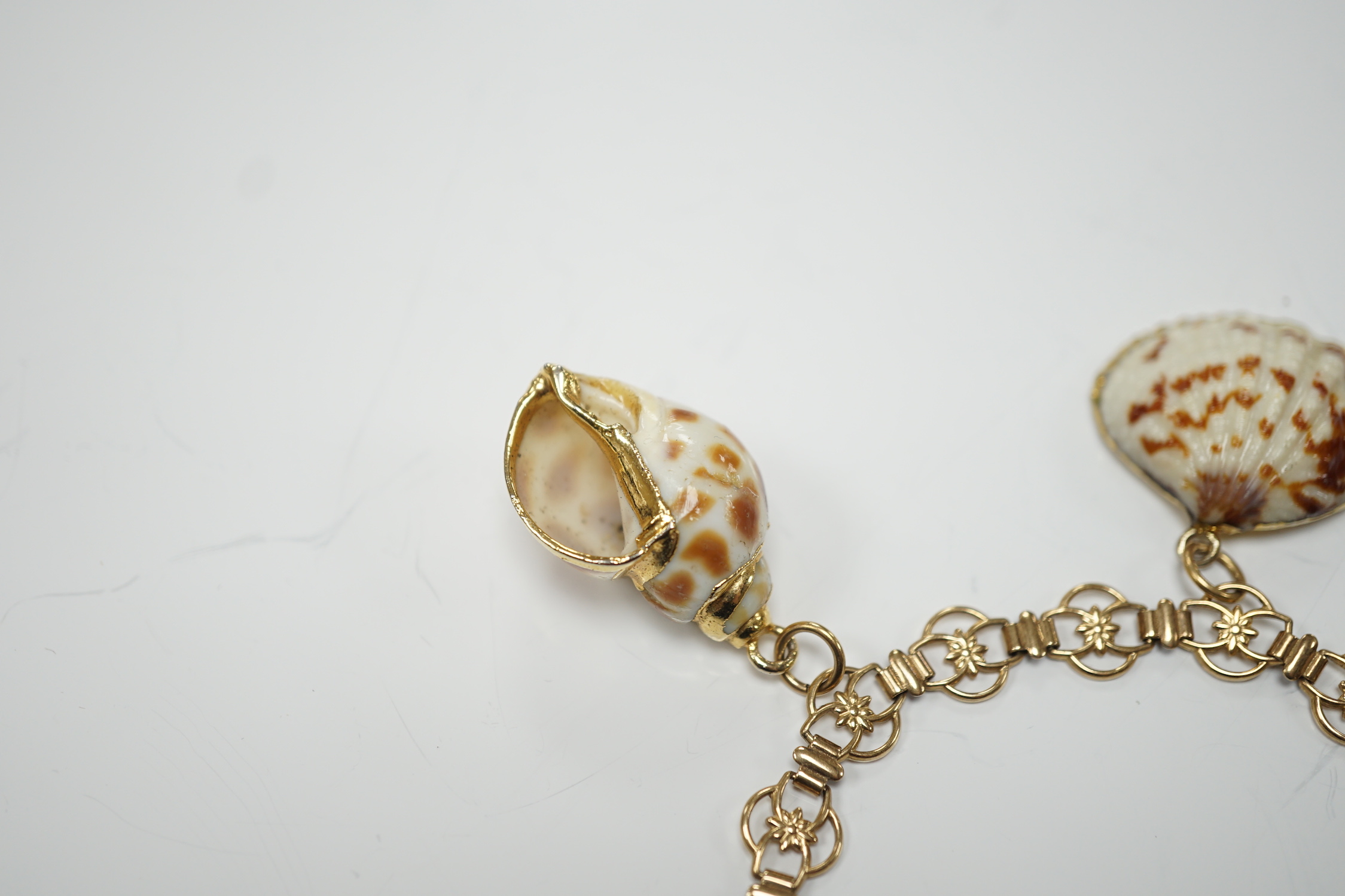 A modern 9ct gold charm bracelet hung with four shell charms, gross weight 19.1 grams.